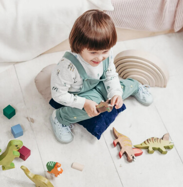 Toddler playing with wooden toy animals